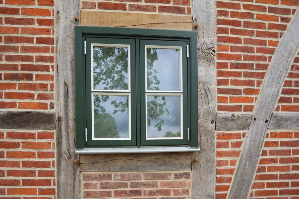 Kiefernholzfenster mit grün-weißer Lackierung von Firma Vrogum mit selbstgefertigtem Blendrahmen und Titanzink-Fensterbank