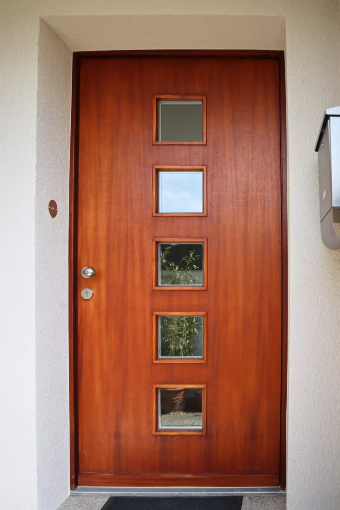 Haustür aus Merantiholz mit 5 quadratischen Lichtausschnitten aus Eigenfertigung