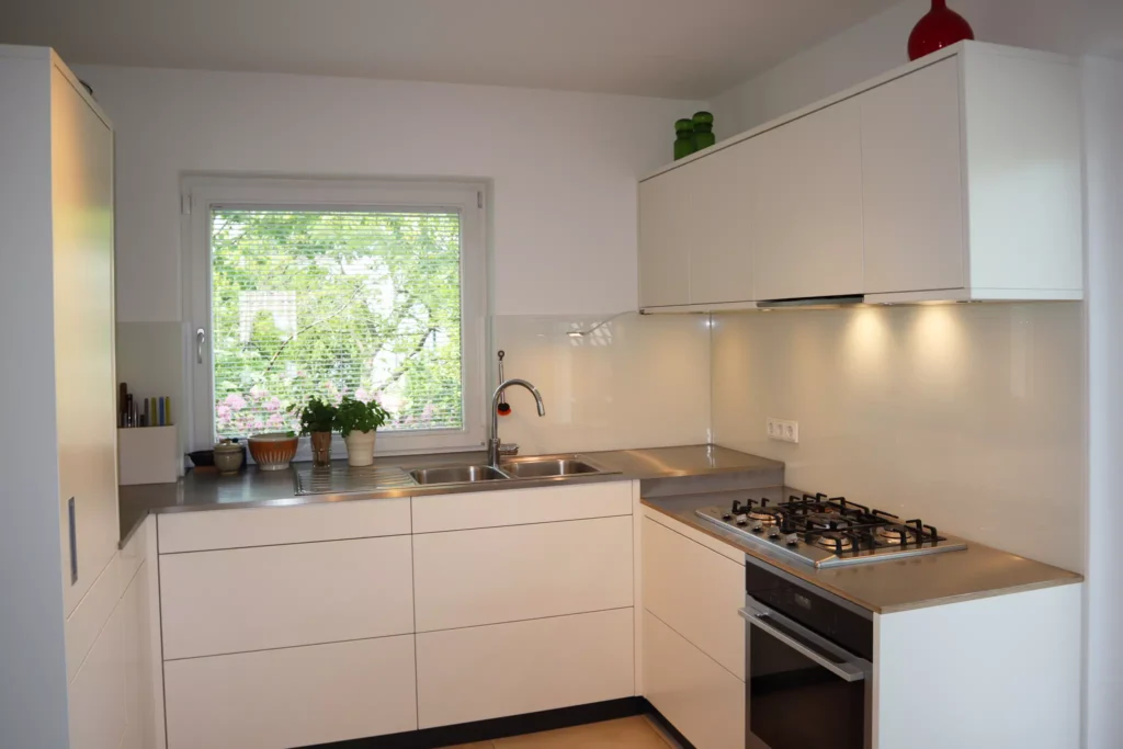 Küche in MDF weiß lackiert mit Edelstahl-Arbeitsfläche und Miele-Geräten 01